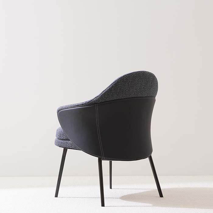 Eigentijdse, blauw gestoffeerde eetfauteuil met gebogen rug