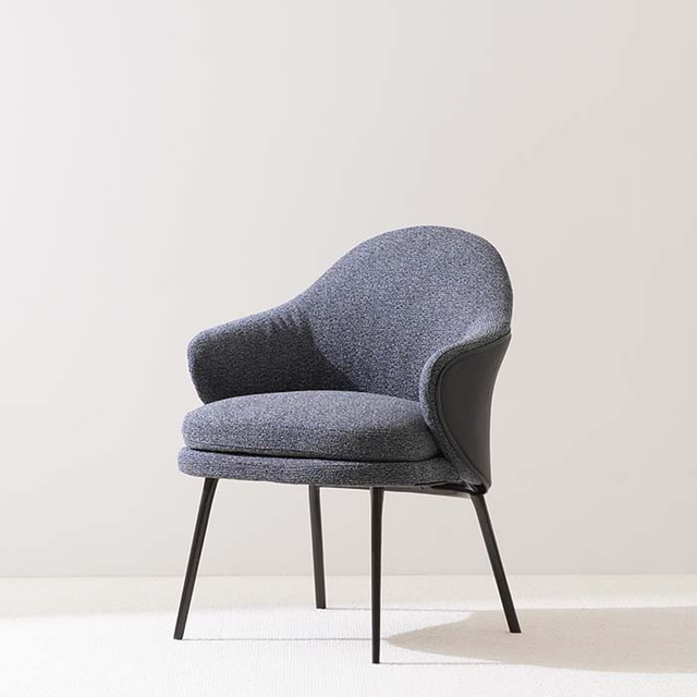 Eigentijdse, blauw gestoffeerde eetfauteuil met gebogen rug